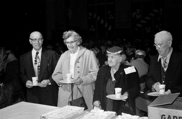 Several senior citizens gather refreshments at the Christmas party put on by Sigma Alpha Epsilon fraternity. From left to right are: Henry Venger, Mrs. Theresa Kurt, and Andrew, and Hilda Nylen.