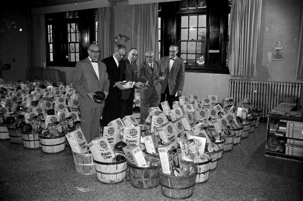 Five members of the Salvation Army advisory board with baskets of food collected for needy families. Left to right are W. B. Miller, E. J. Kallerang, Herbert Loucks, Emanuel Simon, and Walter Thompson.