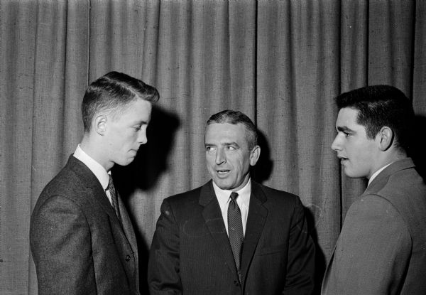 Madison Central football coach Harold (Gus) Pollock with two of his players at the annual Bank of Madison banquet. At left is Dick Putnam, an all-city end. At right is Ed Allen, a co-captain and all-city center.