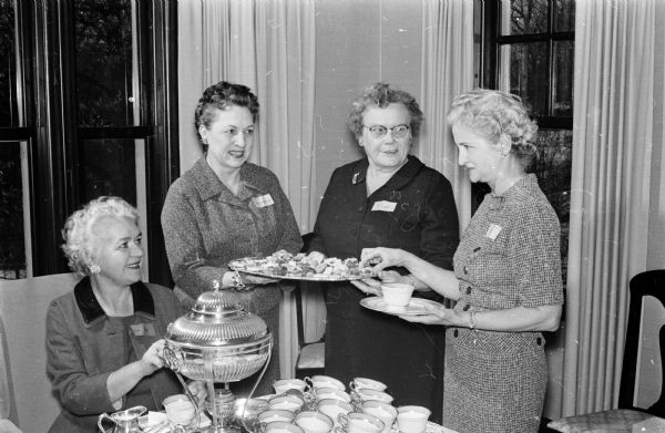Group portrait of four canteen hostesses at the first Red Cross "thank you" tea held at the home of the University of Wisconsin president. Left to right are Mrs. Elizabeth Bell, Mrs. Helen Thomson, Mrs. Opal Rook, and Mrs. H.H. Smith.