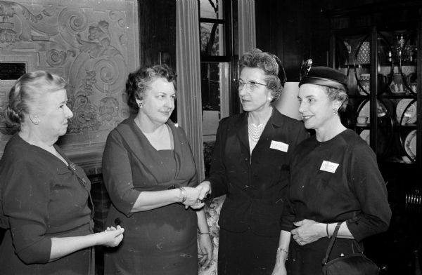 The Red Cross Volunteer "thank you" tea is held at the home of the University of Wisconsin president. Left to right are Mrs. Dorothy Schar, volunteer committee chairman; Mrs. Constance Elvehjem, hostess; and two volunteer registered nurses, Mrs. Emma Goers and Mrs. Merle Bieberstein.