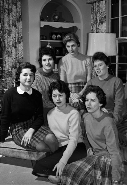 The University of Wisconsin Phi Beta Chi sorority plans a formal New Year's Eve dinner dance at Camp Wakanda. The "Playboys" orchestra will play from 9:00 p.m. until 1:00 a.m. Shown from left to right in front row are: Libby Barnard, posters chairman; Kathy Druckenbrod, decorations chairman; and Cathy Cline, social chairman; second row: Linda Garrott, favors chairman; Jessica Hagan, publicity chairman; and Virginia Crownhart, sorority president.