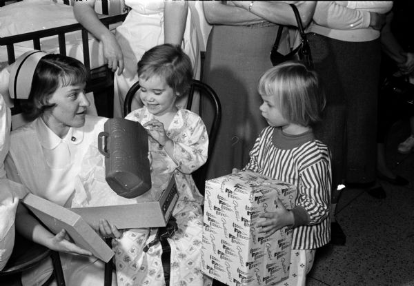 Martha Nelson (right) of Oxford looks on as Mary Anderson examines a toy nurse's kit she received from Santa Claus.
