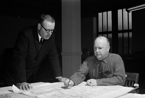 Alfred Plaenert (seated), director of the 1960 census in the Wisconsin Second Congressional district, and Al Cremer, Minneapolis, one of 17 regional directors for the census, discuss plans for the 1960 census.