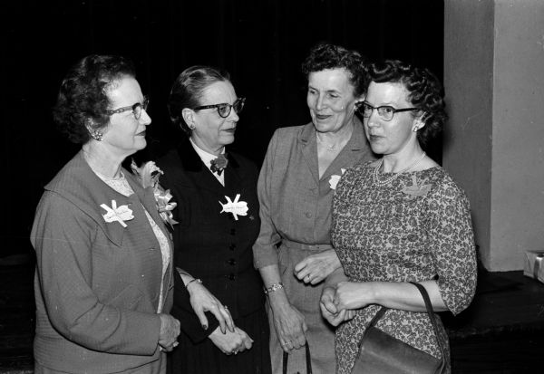 Two state officers greet two new initiates of the BY chapter of the P.E.O. Left to right are: Mrs. R.V. Branham of Rice Lake, Mrs. E.H. Kleinpell of River Falls, Mrs. Marion Webster, and Mrs. Velma Schutz.