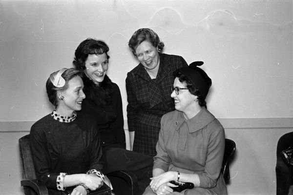 Four women attending the Who's New Club Anniversary Tea. Frances DeNamur, sitting at left, chatting with Lois Sedlacek, Alice Smith, and Marjorie Randell.