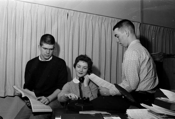 Members of the Madison Youth Council telephone local home owners about providing sleeping rooms for young fans in town for the State Basketball Tournament. Shown (L-R) are: Jim Olson, council president; Jan Fleury, council recording secretary; and Mike Sweeney, service committee chairman.