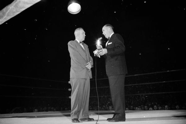 Ike Deeter, left, veteran Washington State boxing coach is honored at a pre-match ceremony by the Downtown Seconds of Madison. John J. Walsh, right, former Wisconsin coach, makes the gift presentation.