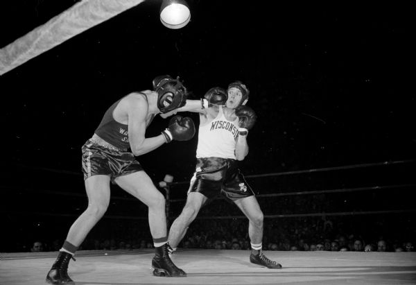 Action shot of a boxing match between Charlie Mohr of Wisconsin (right) and Bob Davido of Washington State.