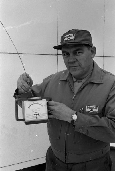 Harold Keller holds a Fotoscope which indicates when engine oil needs changing.