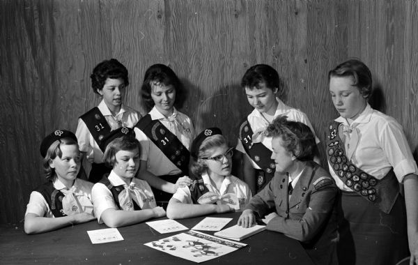 Mrs. Dorothy Conrad talks over plans for the cookie sale with members of Black Hawk Council Girl Scouts of Sherman school Troop 31. Seated scouts are: Judy Willis, Carole Dolgner, and Kathy Lohr. Standing are: Joan Droster, Kathy Kneubuhler, Kathy Carmody, and Brenda McGillivray.