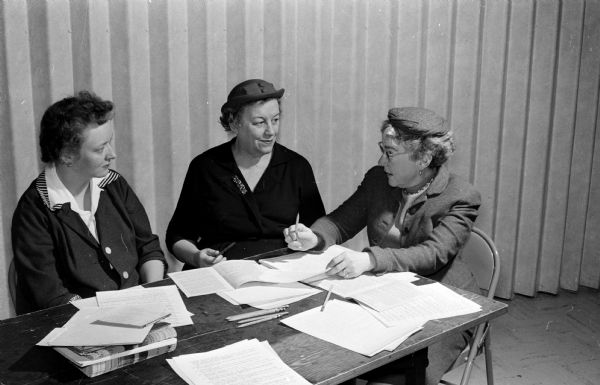 Three women discuss plans for observance of the World Day of Prayer to be held at Bethel Lutheran Church. Left to right, they are: Mrs. Nadeen Roehm, 1961 World Day of Prayer chairman; Mrs. Eva Brewster, Madison Council of United Church Women president; and Mrs. Lora Jackson, 1960 chairman.