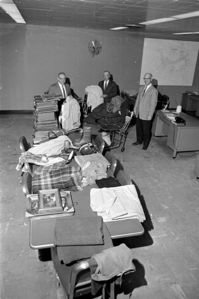 Detectives identifying stacks of stolen merchandise confiscated from a home on Ohio Avenue. Left to right: William Taylor, Frank Freney, and Capt. Thomas Nee.
