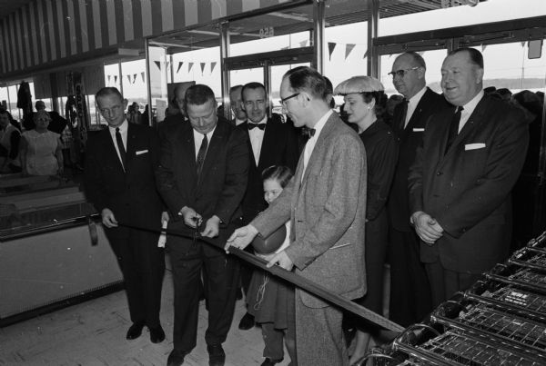 The S.S. Kresge Store was the first store open for business in the new Westgate Shopping Center. Attending the ribbon-cutting ceremony are, left to right: W.L. Schwartz, assistant regional manager for the firm; Alderman Harold Rohr, president of the City Council; J.S. Benner, Kresge district manager; Terry Cole, daughter of the store manager; F.J. Cole, manager of the Westgate store and Mrs. Cole.