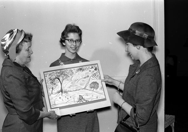 Contest judge Mrs. Daisy Breyer (left) and Central High school art teacher Mrs. Merrie Wisiol (right) admire the painting of Beverly Fries, a fifth-place winner at the Helen Farnsworth Mears art contest for eight graders.