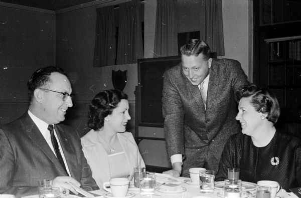 Two past-presidents of the Oregon Rotary Club chat with their wives at the club's ladies night banquet. In the center are Mr. and Mrs. Roland Cross. With them are Mr. and Mrs. Norman Champion.