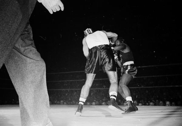 University of Wisconsin boxers clinch a victory over previously unbeaten San Jose State. Jerry Turner, a University of Wisconsin boxer in the white shirt, lands a right, while Bill Maddox prepares to throw a return right.