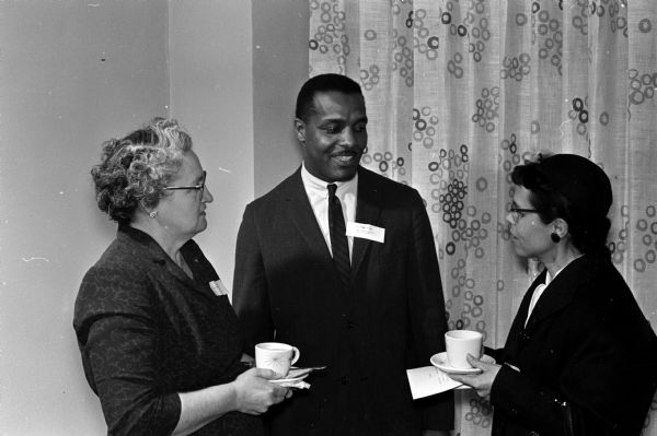 Edwin Robinson, 508 N. Frances Street, a staff member of the Dane County Department of Public Assistance, talks with two foster mothers, Mrs. Edwin Boley, left, and Mrs. Michael Chambers, both of Black Earth.