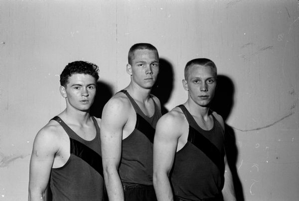 Group portrait of Kenosha's 180-yard high hurdle shuttle relay team which won its specialty in 22.9 seconds. Left to right are: Larry Grimes, Barnard (Buzz) Englung, and Ernie Huxhold.