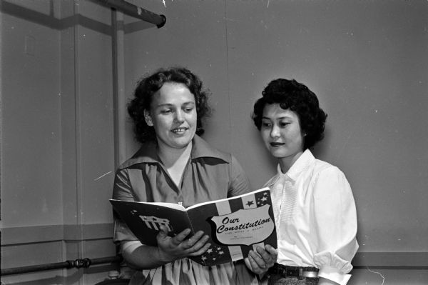 Two students reviewing "Our Constitution and What It Means" for a citizenship course. They are Mrs. Gertrud Wood, Germany, and Mrs. Sucko Miller, Japan.