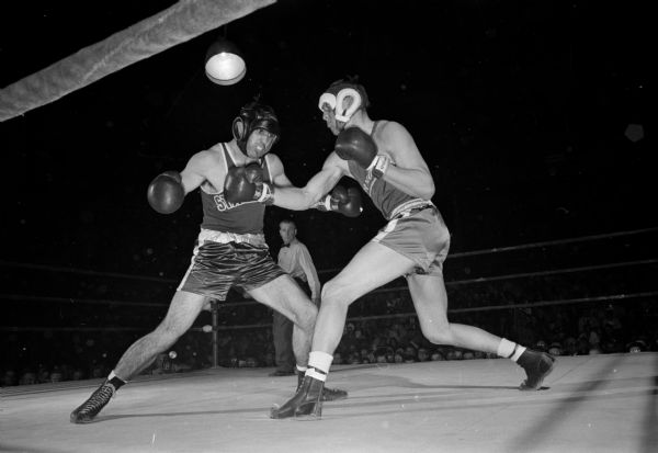Action shot of Ed Rothman of Stanford and John Genasci of Nevada in their Thursday heavyweight bout during the NCAA boxing tournament at the University of Wisconsin field house. Rothman scored TKO win to advance to the semi-final round Friday.