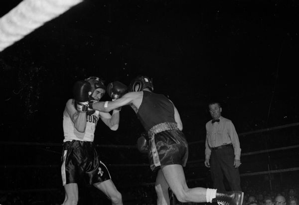 Wisconsin's Jim Mack (left) and Reiji Shimabukuro of College of Idaho in their championship bout during the NCAA boxing tournament at the University of Wisconsin field house. Shimabukuro retained his title.