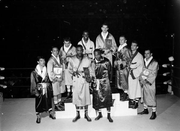 Portrait of the ten individual champions of the twenty-third NCAA boxing tournament held at the University of Wisconsin field house. In front, left to right, are: Archie Milton, San Jose State, heavyweight, and John Horne, Michigan State, 178-pounds. In back, left to right, are: Heiji Shimabukuro, College of Idaho, 112 pounds; Ron Nichols, San Jose State, 119 pounds; Dave Nelson, San Jose State, 125 pounds; Brown McGhee, Wisconsin, 132 pounds; Steve Kubas, San Jose State, 139 pounds; Mills Lane, Nevada, 147 pounds; Jerry Turner, Wisconsin, 156 pounds; and Stu Bartell, San Jose State, 165 pounds.