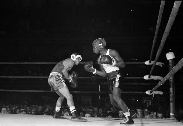 Wisconsin's Brown McGhee (right) and Joe Bliss of Nevada participate in their championship bout during the NCAA boxing tournament at the University of Wisconsin field house. McGhee unseated the former champion to become the first of two Wisconsin NCAA champions.