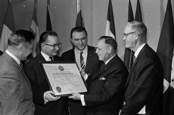James R. Jacobson (left), secretary, and William R. Cress, president, receive the charter for the new Sun Prairie Rotary Club from Lee H. Barker, Wisconsin Rapids, governor of Rotary District 625. Col. Edward Silvers (center), vice-president, and H. Russell Twiton, treasurer, look on.