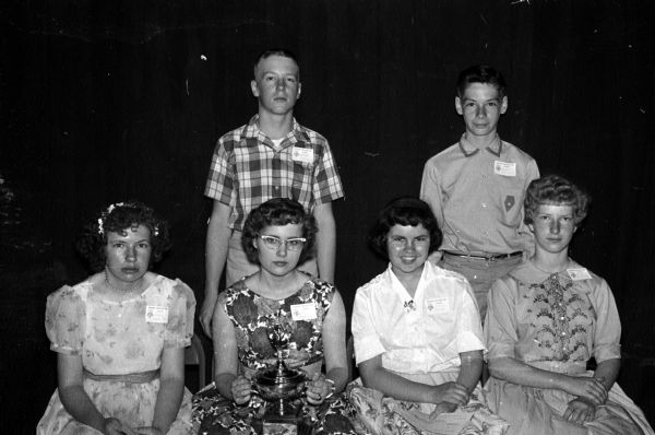 Among the spellers placing at the top at the state finals are, front row, left to right: Gloria Ogorzalek, Lublin, forth place; Judy Anne Nichols, (holding the trophy), Sharon, the winner; Rose Adler, Waunakee, second place; Marjorie Ellefson, Medford, third place; second row: Allen Johnson, Prentice, seventh place; and Robert Frahm, Union Grove, fifth place.