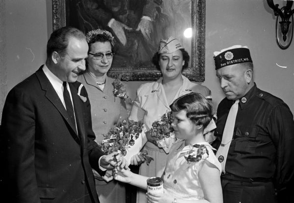 Governor Gaylord Nelson purchases the first red poppy to start the annual joint veterans organizations poppy sales days. Shown, left to right, are: Gov. Nelson, Mrs. Ben Bergor, American Legion Unit 57 auxiliary poppy committee chairman; Mrs. Carol L. Bussian, immediate past president of Marton C. Cranefield Post 1318 VFW auxiliary; Debra Kay Bussian; and Alfred Gerke, commander of Donald S. Severson Post 501, American Legion.