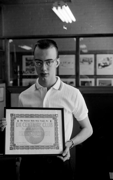 Madison ham radio hobbyist Philip Goetz, age 17, poses with his DX Century Club award from the American Radio Relay League, Inc., for conducting two-way communication with other amateur stations in at least 100 different countries.