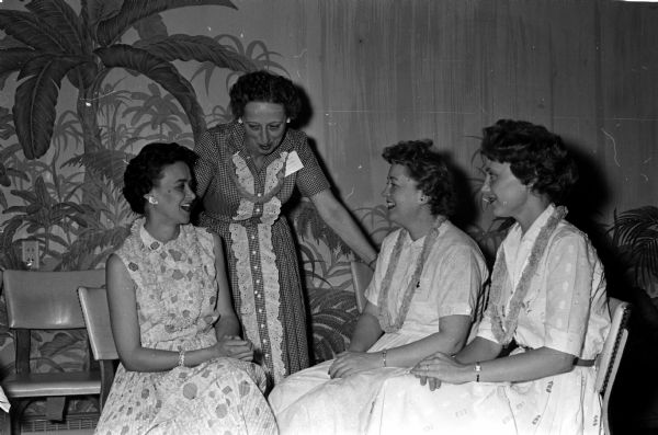 Four Beta Sigma Phi members are shown conversing at the convention. They include, from left, Ruth Wellman, Madeline Shako, Corrine Wakeman, and Betty Kriese.