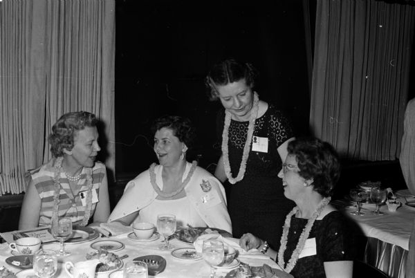 Four delegates from St. Paul, Minnesota are seated at a table during the Beta Sigma Phi convention. They are, from left, Dell Larson, Mrs. Raymond Grohs, Kathryn Caldwell and Mrs. Glenn Bateman.