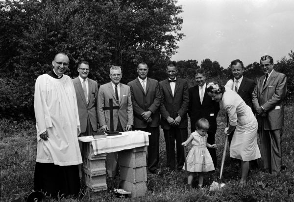 Dorothy Palmquist and her daughter Heidi break ground for a temporary chapel at 2001 Martha Lane for the Messiah Lutheran congregation.  Watching, from left to right, are Rev. Donovan Palmquist, pastor; Robert Johnson; George Hansen; Gene Giese; Roger Jensen; Lester Stockner; Donald McCray and Albert McGinnis, all board of administration members.