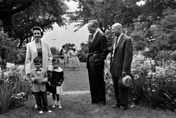 A number of children and husbands of YWCA members gathering while the YWCA has its annual garden tea in the garden of Sybil Hanks at 525 Wisconsin Avenue. At left is new board member Marie Thomas, with two of her children, Philip and Diana. Nearby are Supreme Court Justice Thomas Fairchild, and Stanley Nerdrum, whose wives are also newly elected board members.