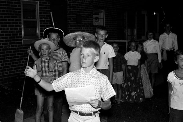 Children living at the Sherman Terrace Apartments perform "The Sad Sullivan Show" at their outdoor theater for parents and friends to raise money for a new home for Winkie, the Vilas Zoo elephant. Playing the title role of Sad (Ed) Sullivan is Jeff Kundert, son of Mr. and Mrs. Robert Kundert, and a 6th grade student at Lapham School. Jeff is master of ceremonies and introduces the various acts that are presented.