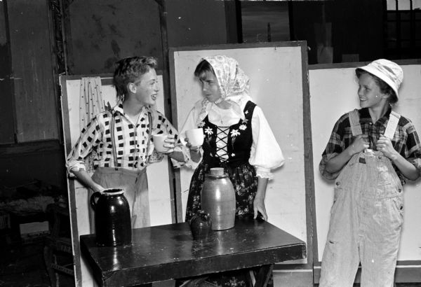 Madison Theater Guild's Youth Summer Theater presents the adult show Tolstoy's "The First Distiller" in the Washington School auditorium. The play is directed by Mrs. Helen Zawacki. Shown (left to right) are Al Schmiedeke, Ellen Davis, and Debbie Holmes.