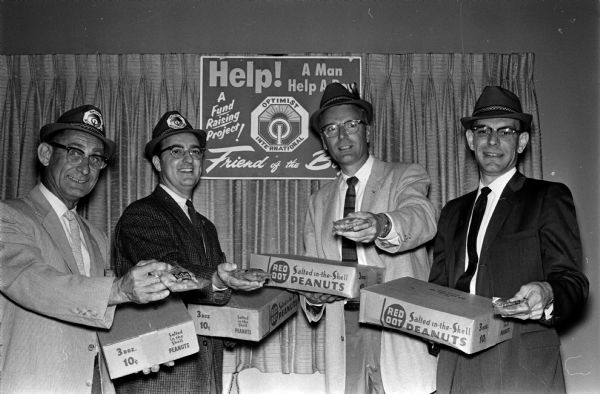 Four members of the Madison West Optimist Club demonstrate their sales technique to sell peanuts to raise funds for boys' activities. Left to right are: Blue Schmelzer, Nick Stassi, Clyde Selix, and Martin Matoushek.