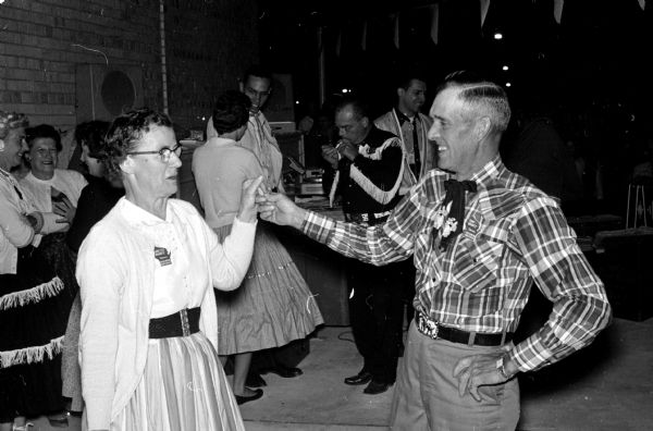 Mr. and Mrs. Tony Krantz of Verona participate in a square dance at the Westgate Shopping Center as part of a Montgomery Ward open house.