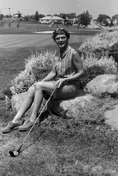 Dorothy Webber, president of the Municipal Golf Association, models Bermuda shorts and a sleeveless blouse.
