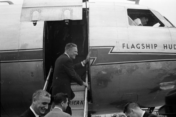 Henry Cabot Lodge, Jr. waves good-bye as he boards an airplane after a 90 minute campaign visit to Madison.