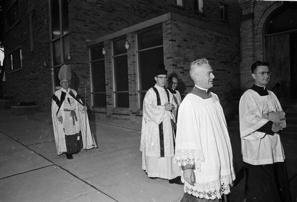 Bishop William P. O'Connor of the Madison diocese walking in a procession at the dedication of the new building for St. Patrick's convent, 30 S. Franklin Street. He is preceded by, left to right, the Rev. Ronald Rank, assistant pastor of St. Patrick's Catholic Church, and Msgr. Jerome Hastrich, vicar general of the Catholic diocese of Madison.