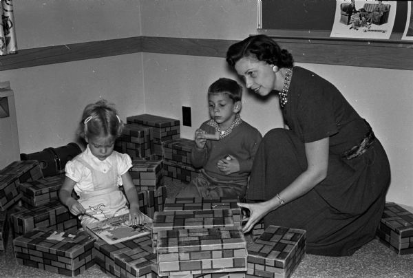 Irene Larsen, director of the Luther Memorial Church Nursery School, is shown with two of the children, Lynnea Ekestrom and Craig Lang.