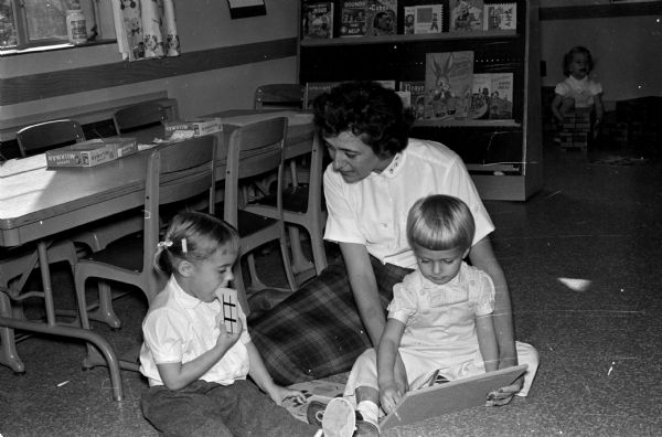 Teacher Jean Kasinski assists with nursery school classes at Luther Memorial Church. The children are, left to right, Cathy Copps and Linda Stephl.