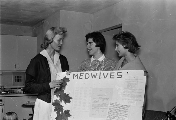 A monthly bulletin board has been prepared for meetings of the Med-Wives group of the University of Wisconsin Medical School. The Med-Wives is an association of the wives of University of Wisconsin medical students. Left to right are: Helen Burgermeister, Phyllis Andringa and Carol Bensman.
