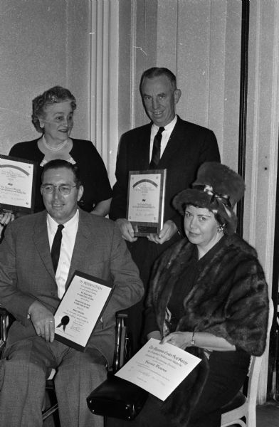 Group portrait of four award winners at the annual meeting of the Wisconsin Easter Seal Society. In back are: Mrs. Frank Rehauer of Two Rivers and Ralph Ells, public relations director for Allen-Bradley Company of Milwaukee. In front are: Donald J. MacFarlane of Janesville and Harriet Westover of Milwaukee. Allen-Bradley Company was honored for its support of the society. Mrs. Rehauer and Miss Westover were honored for their service to the Easter Seal program. MacFarlane received the society's national Gallantry award for his "outstanding adjustment to a severe physical handicap."