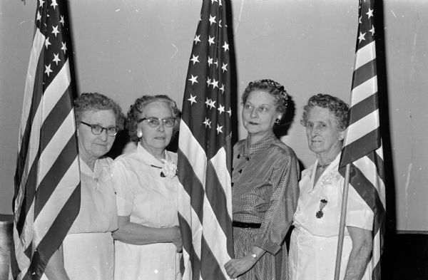 Members of the Lucius Fairchild Women's Relief Corps No. 37 present a U.S. flag to the newly formed World War I Auxiliary in a ceremony held at the GAR Memorial Hall, located at 118 Monona Drive. Shown from left are Mrs. Emma Grahm, Mrs. Catherine Kuehn, Mrs. Kathryn Dewey, and Mrs. Jennie Bambrough.