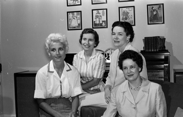 Group portrait of members of the University League and its Junior division who are in charge of arrangements for a tea for visiting faculty wives and faculty women. In the foreground: Mrs. John Du Bois and Janet Washa. Background: Mrs. Larry Goldbeck and Cynthia Youmans.