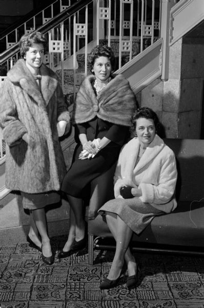 Mary Niglis, Elizabeth Maloof, and Marion Sweeney wearing furs they will model at a program for the wives of men attending the Fourth Degree Knights of Columbus conclave.